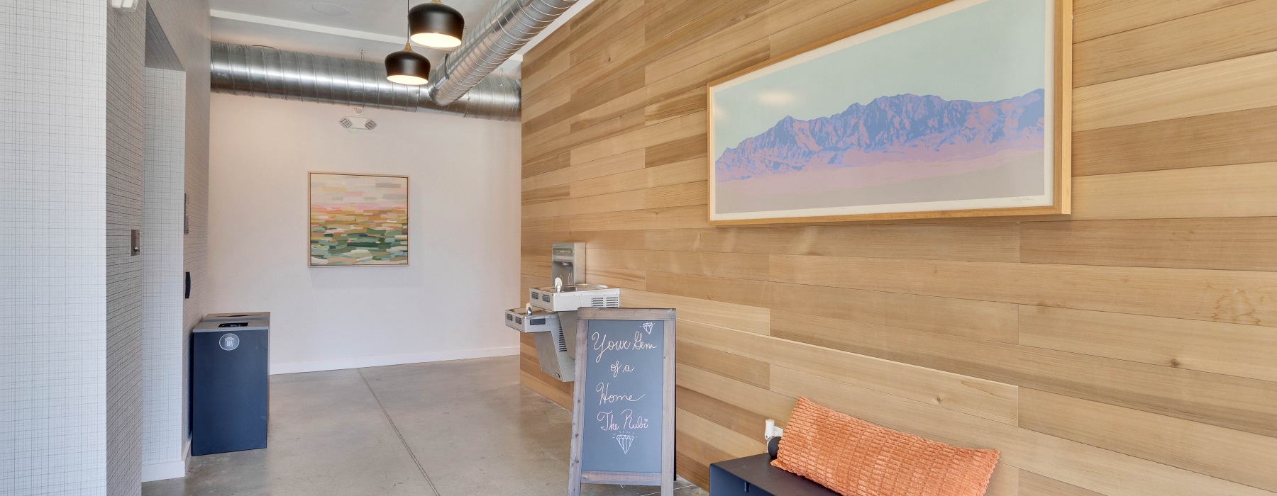 a room with a bench and a painting on the wall