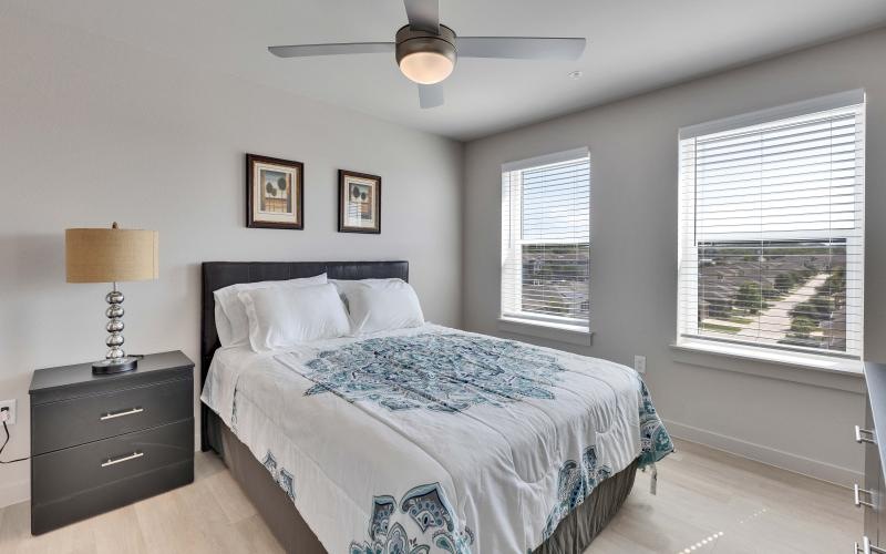 a bedroom with a bed and a fan